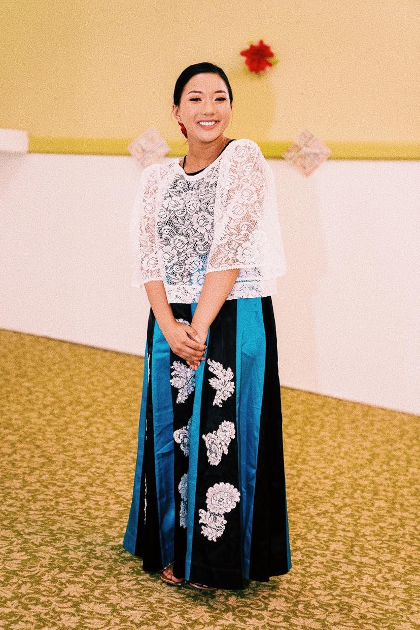 Filipino American woman smiling and wearing traditional attire